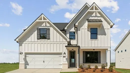 Modern two-story white farmhouse with black shutters, a double garage, and a well-maintained front lawn on a sunny day