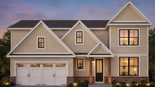 Modern two-story beige house with large windows and a double garage at sunset with warm interior lights.