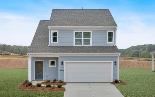 Two-story blue house with gray roof, double garage, and manicured front yard under clear sky.